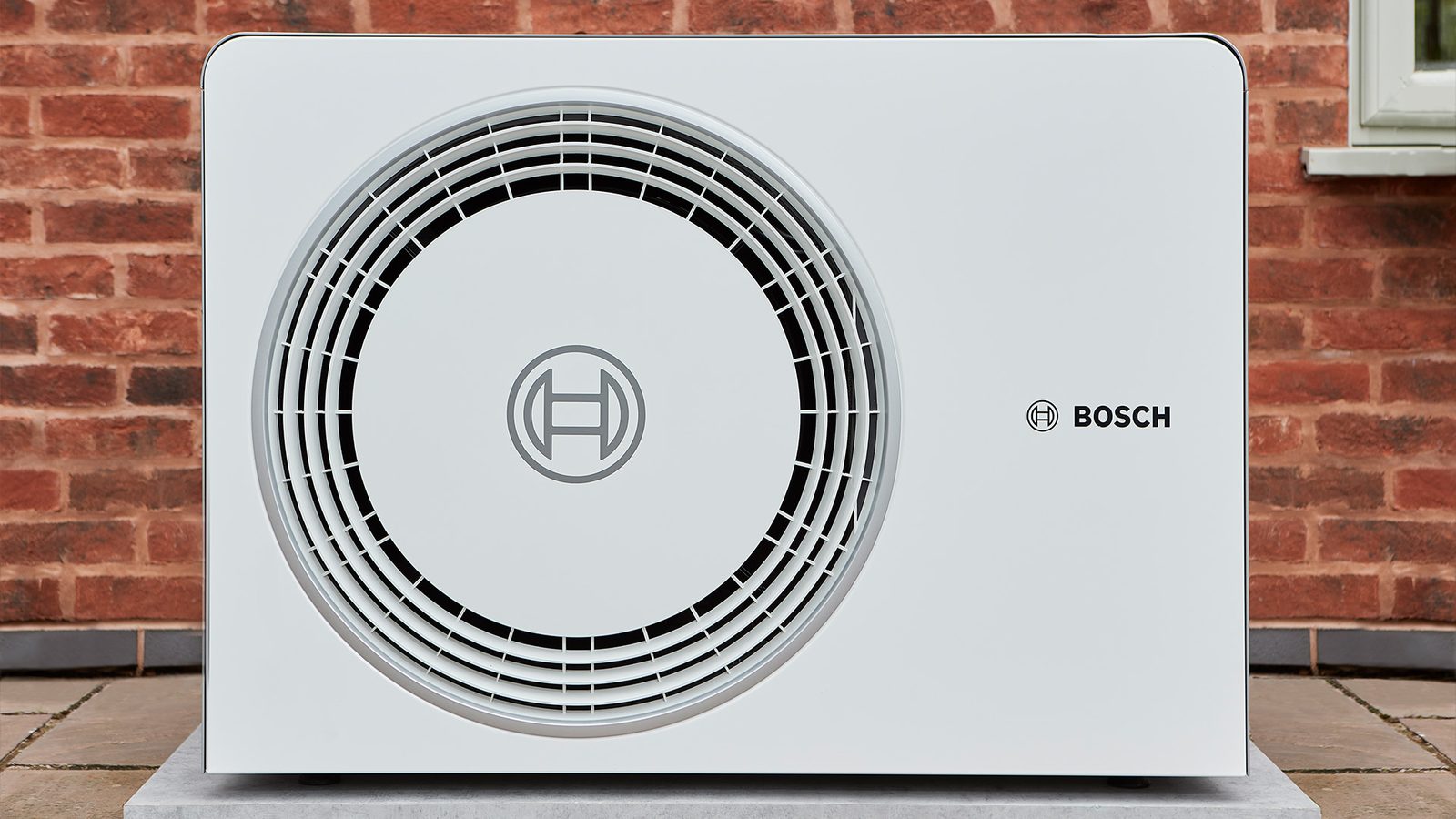 Bosch Compress air source heat pump outdoor unit installed against a brick wall